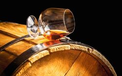 Cognac-Glas auf einem Holzfass