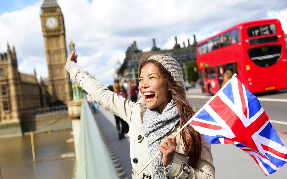 London - glückliche Touristin hält britische Flagge am Big Ben