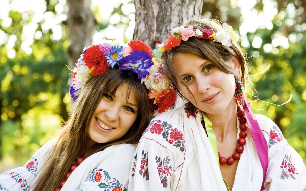 Two girls in national slavic costumes at outdoor.