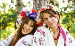 Two girls in national slavic costumes at outdoor.