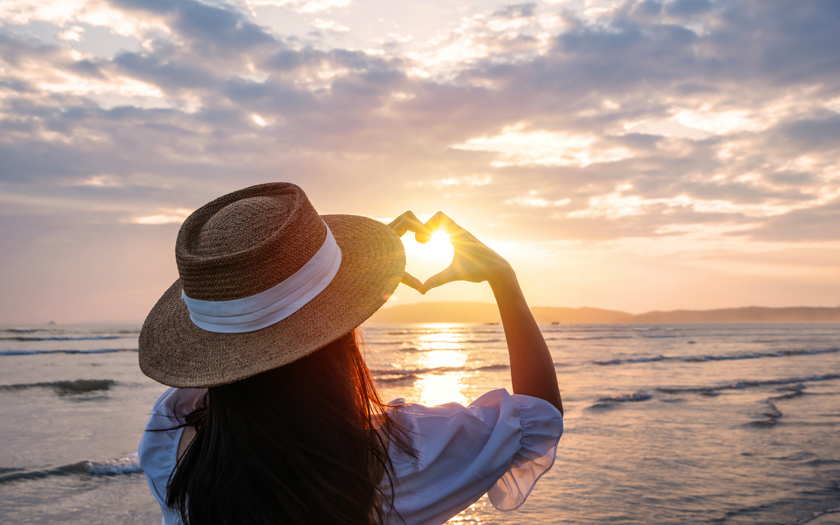 Reisende formt mit den Händen eine Herzform