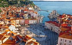 Schöne Luftaufnahme auf Piran Stadt mit Tartini Hauptplatz, alte Gebäude mit roten Dächern und Adria im Südwesten Sloweniens