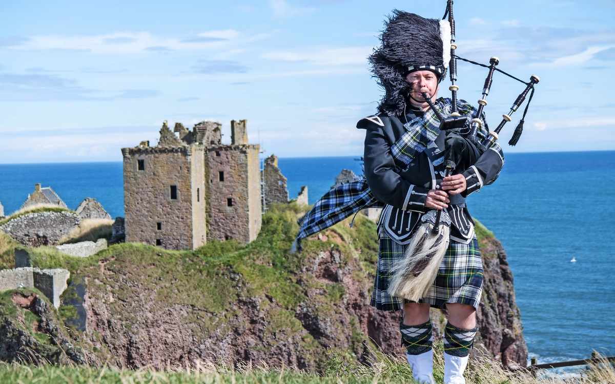 schottischer Dudelsackspieler vor Dunnottar Castle in Stonehaven