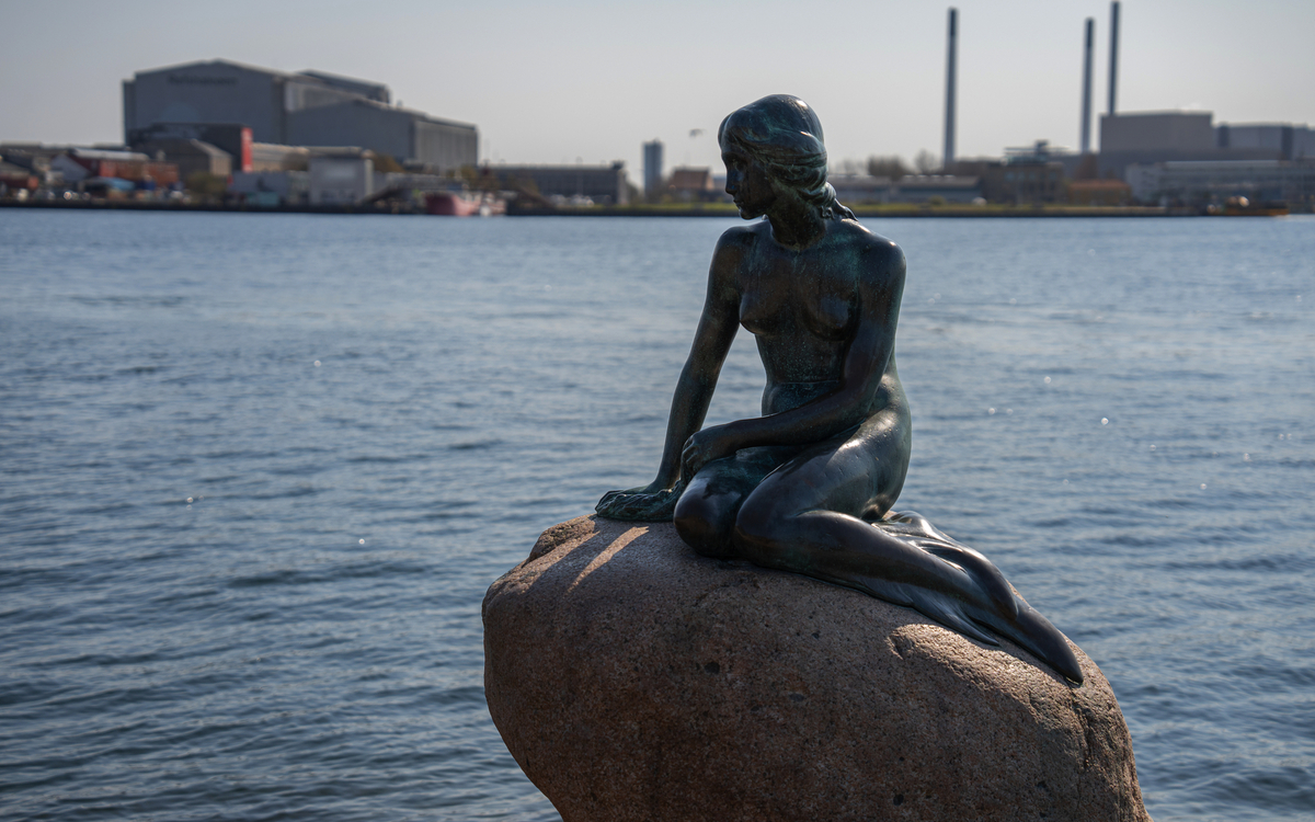 Statue der kleinen Meerjungfrau mit Blick auf den Hafen in Kopenhagen
