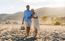 schönes, glückliches älteres Paar, das im Sommer am Meer spazieren geht