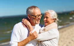 glückliches älteres Paar umarmt sich am Strand