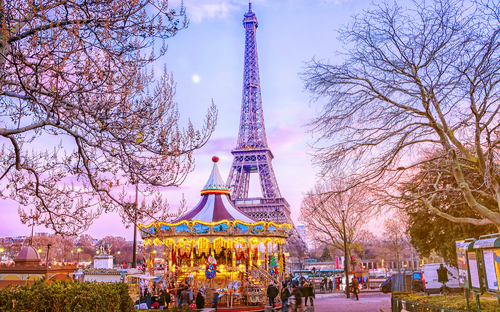 Eiffelturm hinter Karussell an einem Winterabend in Paris