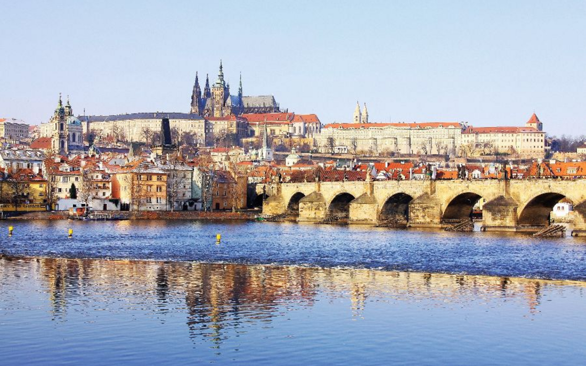 Snowy Prague gothic Castle with Charles Bridge in the sunny Day