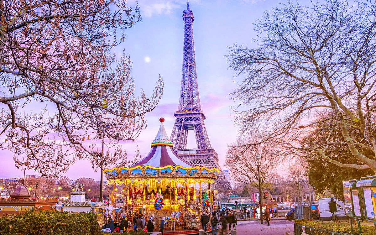 Eiffelturm hinter Karussell an einem Winterabend in Paris