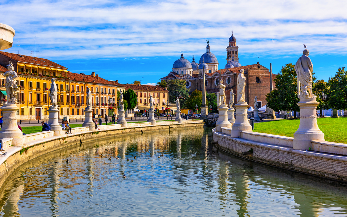 Blick auf den Kanal mit Statuen auf dem Platz Prato della Valle und die Basilika Santa Giustina in Padua